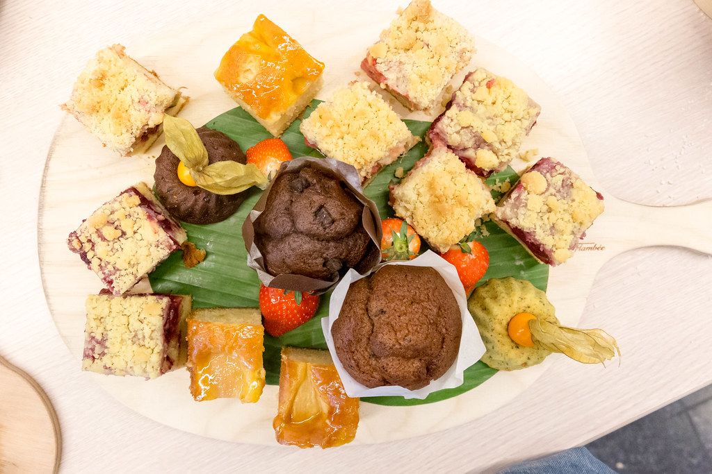 Top view of sweet dessert with fruit cake and chocolate muffins on a wooden board, at AXA's Barcamp OMWest19 in Cologne, Germany