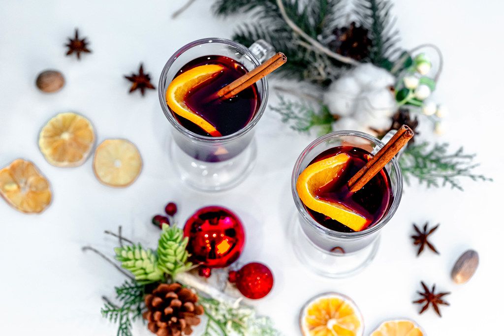 Top view of two glasses of mulled wine with christmas decor on a white background