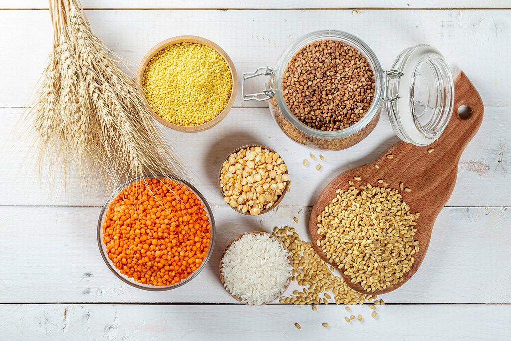 Top View Photo of Grain such as Rice, Wheat, Millet, Lentils, Peas and Buckwheat on white Wooden Table