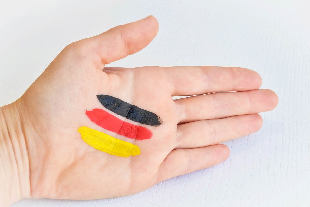 Top View Photo of Hand with Black, Red and Gold Paint in Stripes as Germany Flag