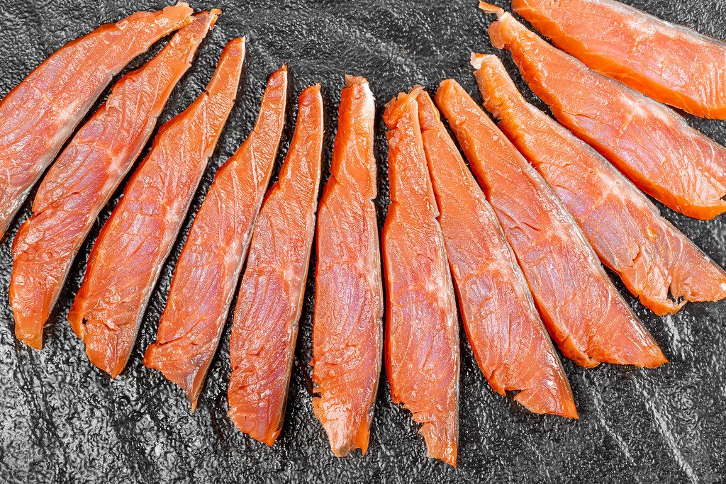Top view sliced pieces of smoked red fish fillet