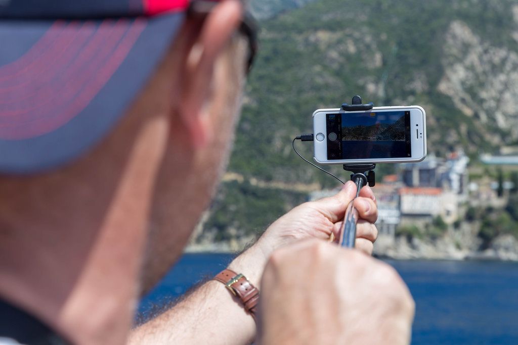 Tourist fotografiert das Kloster Moni Osiou Grigoriou mit seinem Handy