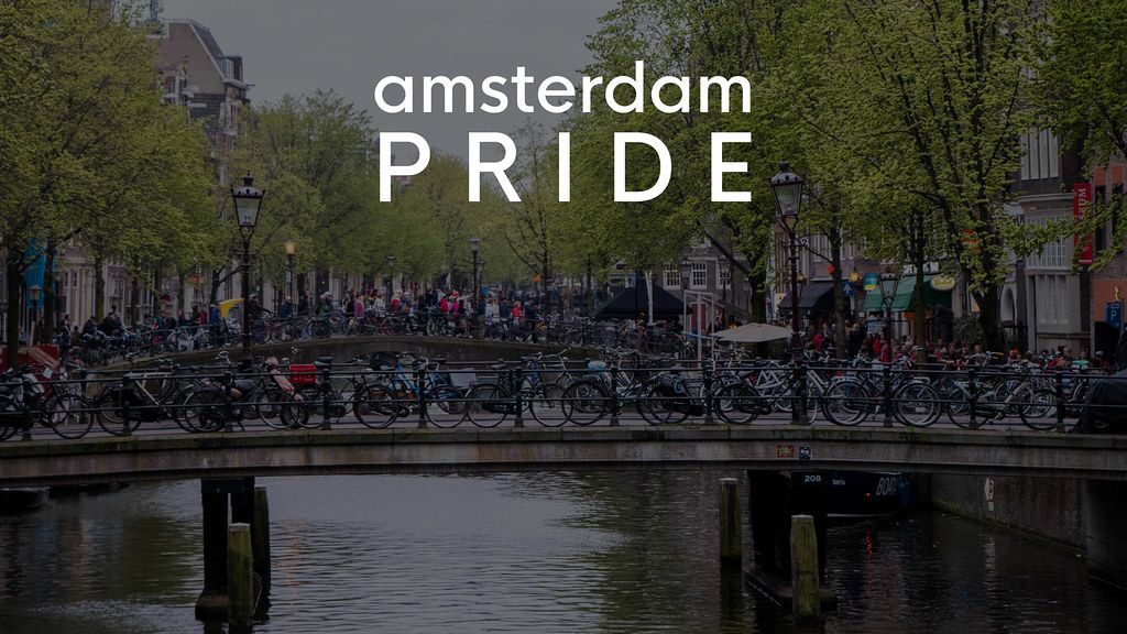 Touristen und Fahrräder auf niederländischen Brücken im Rotlichtviertel von Amsterdam, mit dem Bildtitel Amsterdam Pride