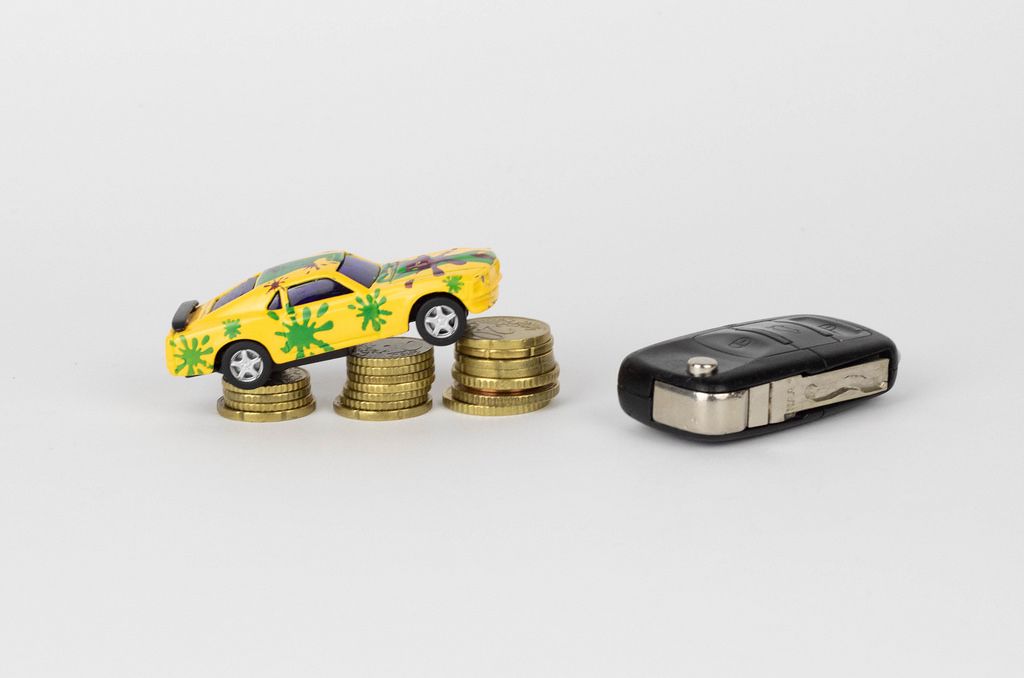 Toy car on coin stack with car keys