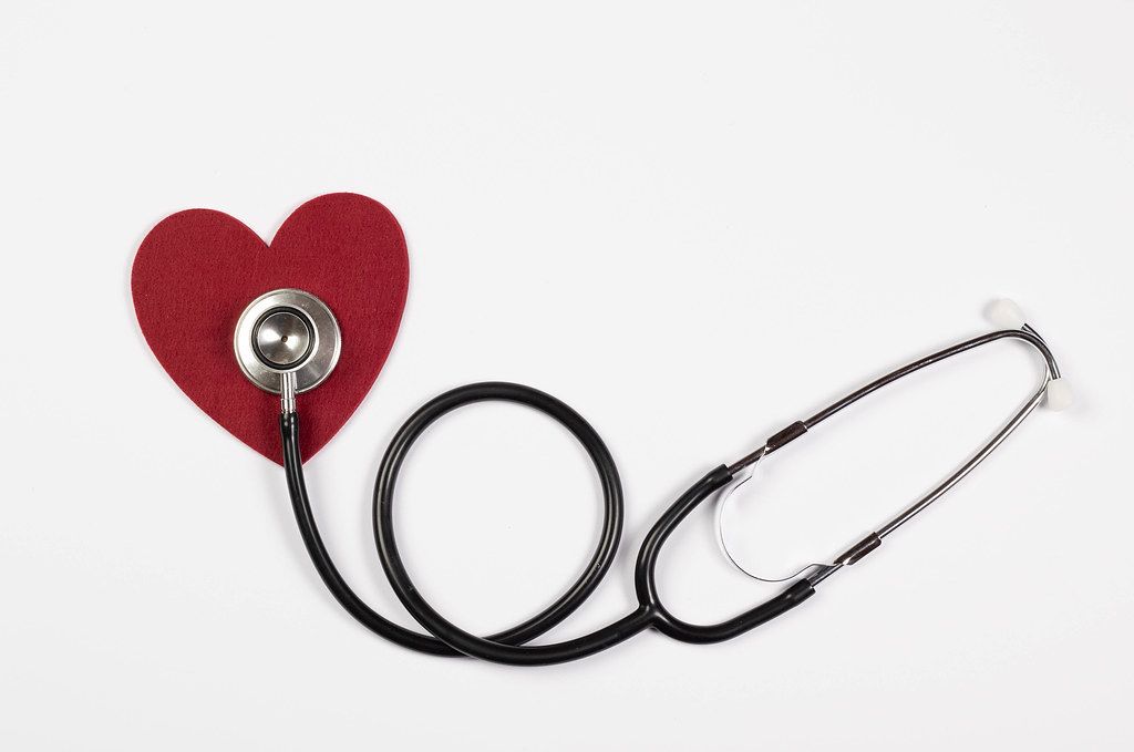 Traditional stethoscope with a red heart on white background