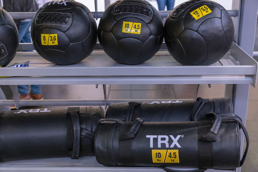 TRX Trainingsutensilien mit schwarzen Medizinbällen in verschiedenen Gewichten auf der Fitnessmesse Fibo in Köln