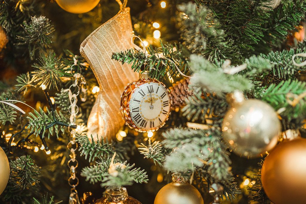 Uhren Dekoration am Weihnachtsbaum mit einer goldenen Socke und Kugeln