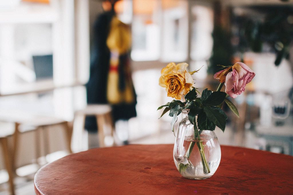 Vase with flowers in a cafe. Colorful blurry background.