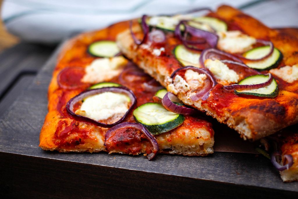 Vegetarische Pizza mit Zucchini und roten Zwiebeln