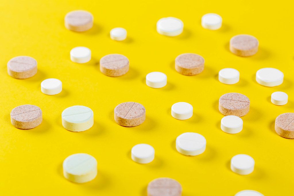 Viele verschiedene Tabletten auf gelbem Untergrund
