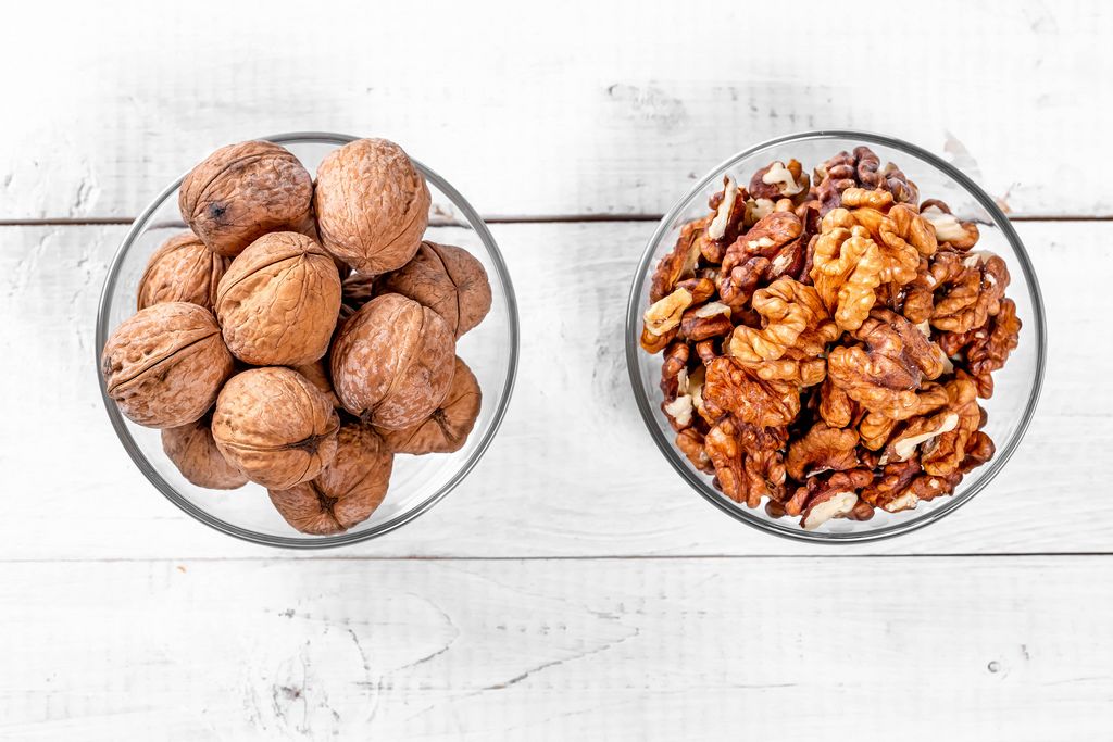 Walnut kernels and whole nuts in glass bowls
