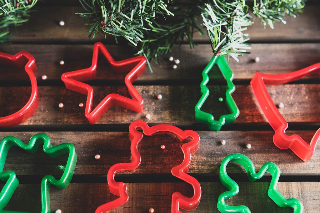 Weihnachts-Plätzchenformen mit Tannenzweigen auf Holz-Untergrund