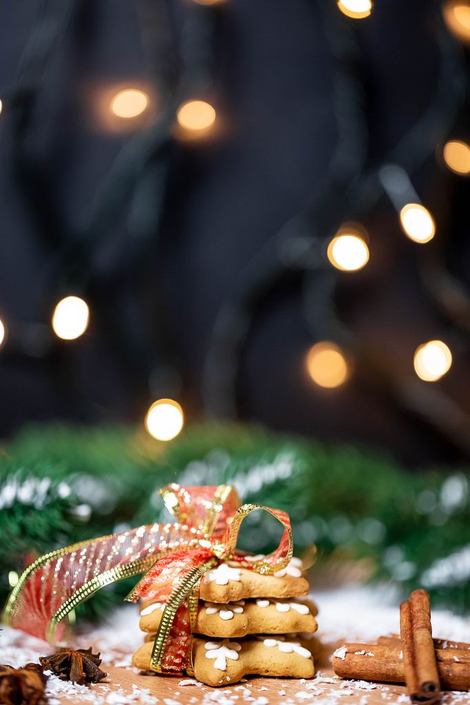 Weihnachtsplätzchen in Sternform mit Schleife und Zimtstangen