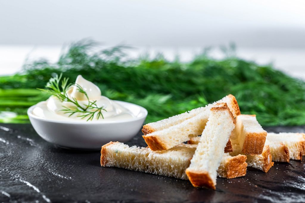 White bread snacks with sauce and herbs