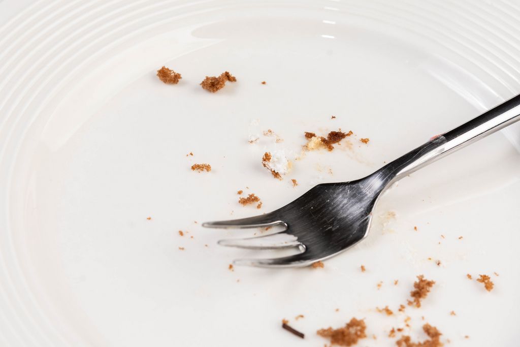 White empty Plate with piece of Cake Leftovers and Fork