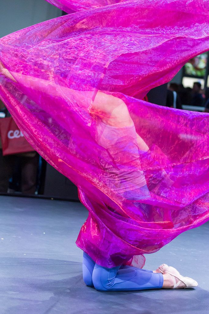 Woman dancing at Photokina in Cologne covered in pink scarf