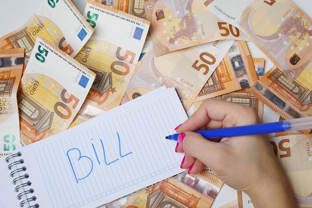 Woman hand writing Bill, 50 Euro banknotes background
