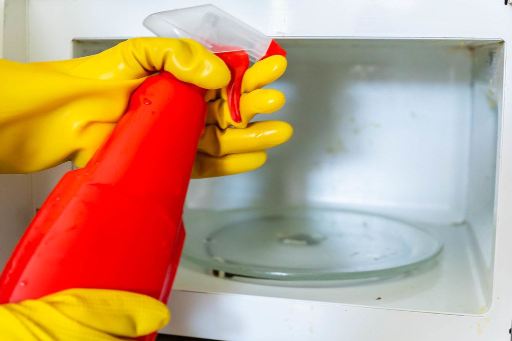 Woman hands in rubber gloves washing microwave (Flip 2019)