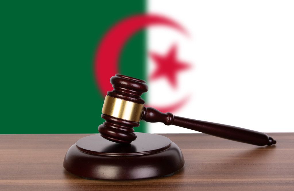 Wooden gavel and flag of Algeria