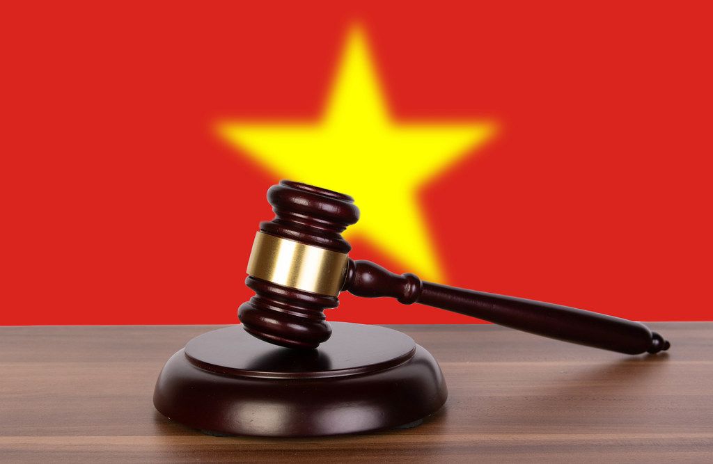 Wooden gavel and flag of Vietnam