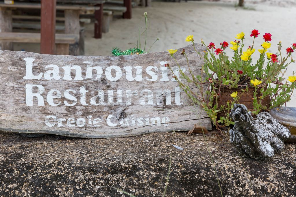 Wooden sign of Lanbousir Restaurant - Creole Cuisine in La Digue in the Seychelles