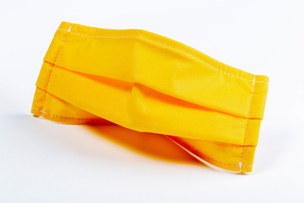 Yellow medical mask on a white background. Individual protection from respiratory diseases