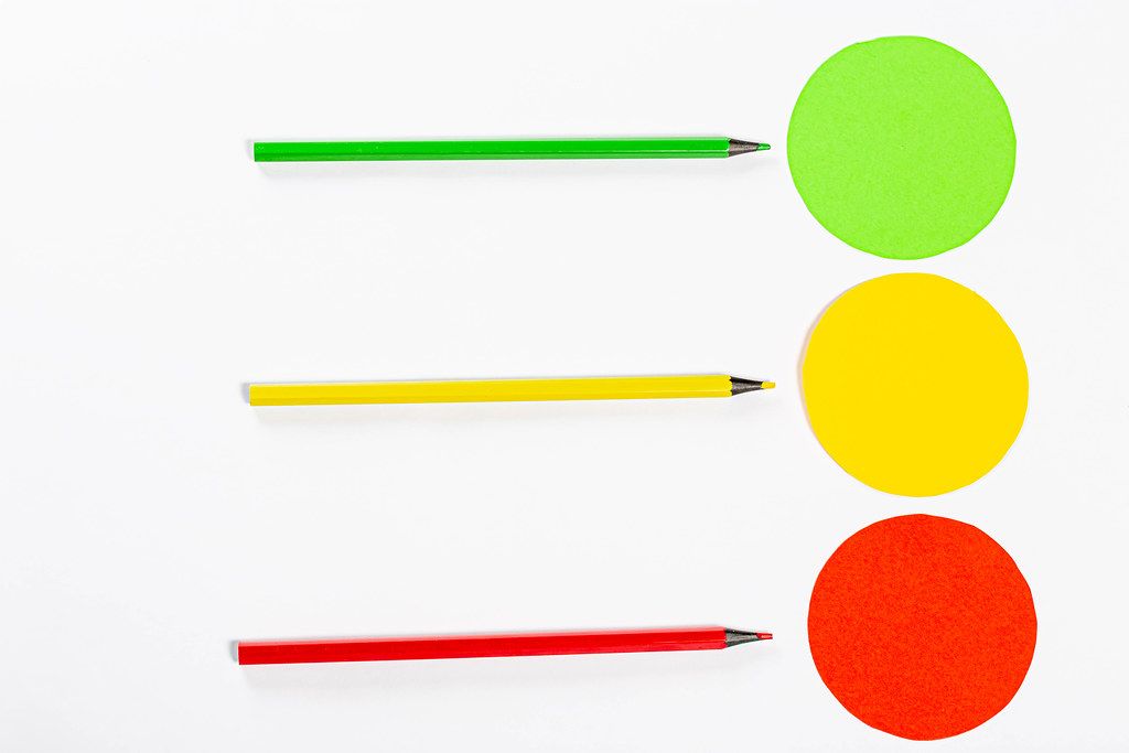 Yellow, red and green circle with colored pencils on white background