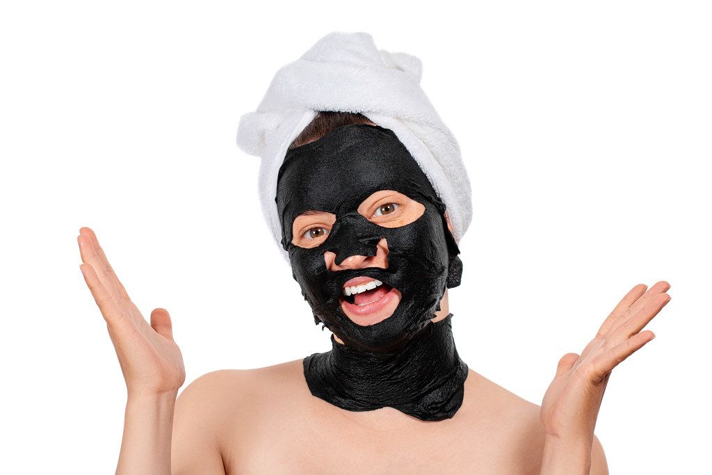 Young beautiful woman in a black mask for the face