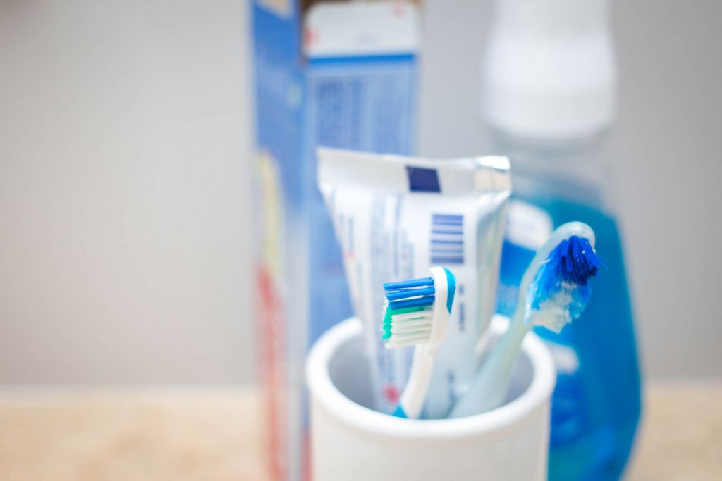 Zahnbürsten mit Zahnpaste in einem Becher - Badezimmer