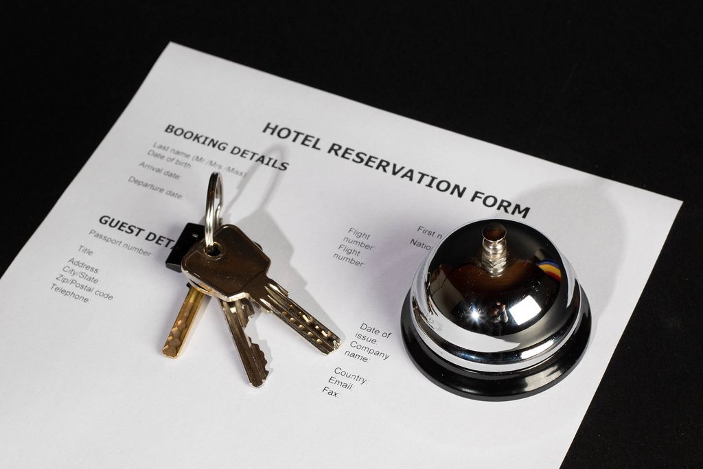 Zimmerreservation in Hotel mit Reservationsbestätigung, Hotelklingel und Schlüssel