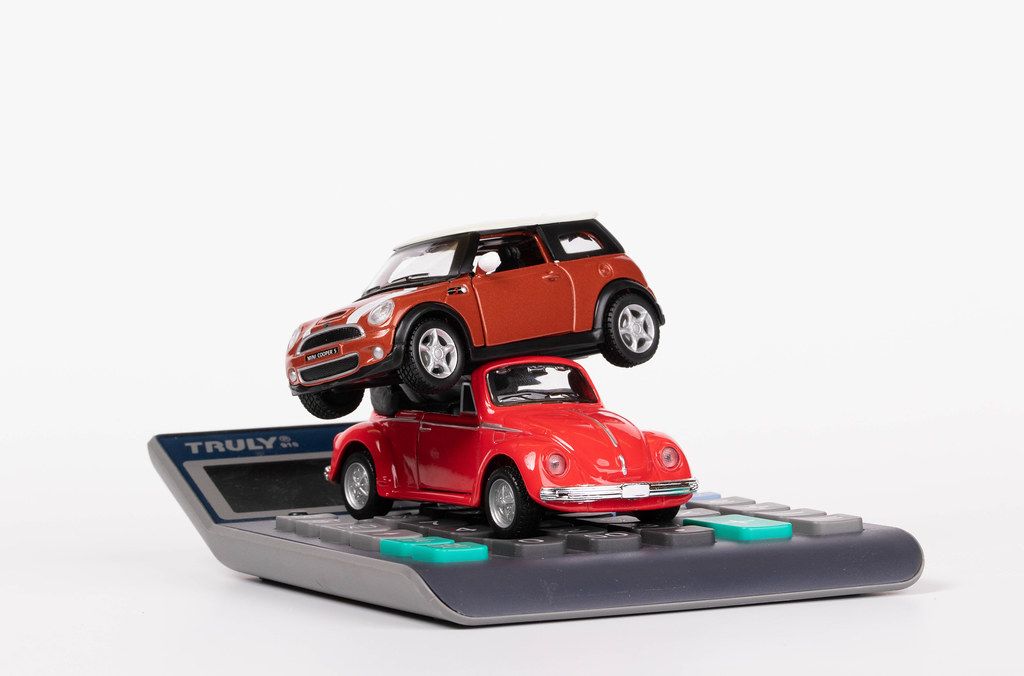 Zwei rote Spielzeugautos auf einem Taschenrechner