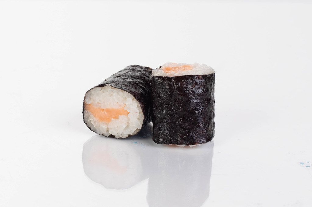 Zwei Sushi Maki Rollen mit Lachs im weißen Hintergrund - Creative ...
