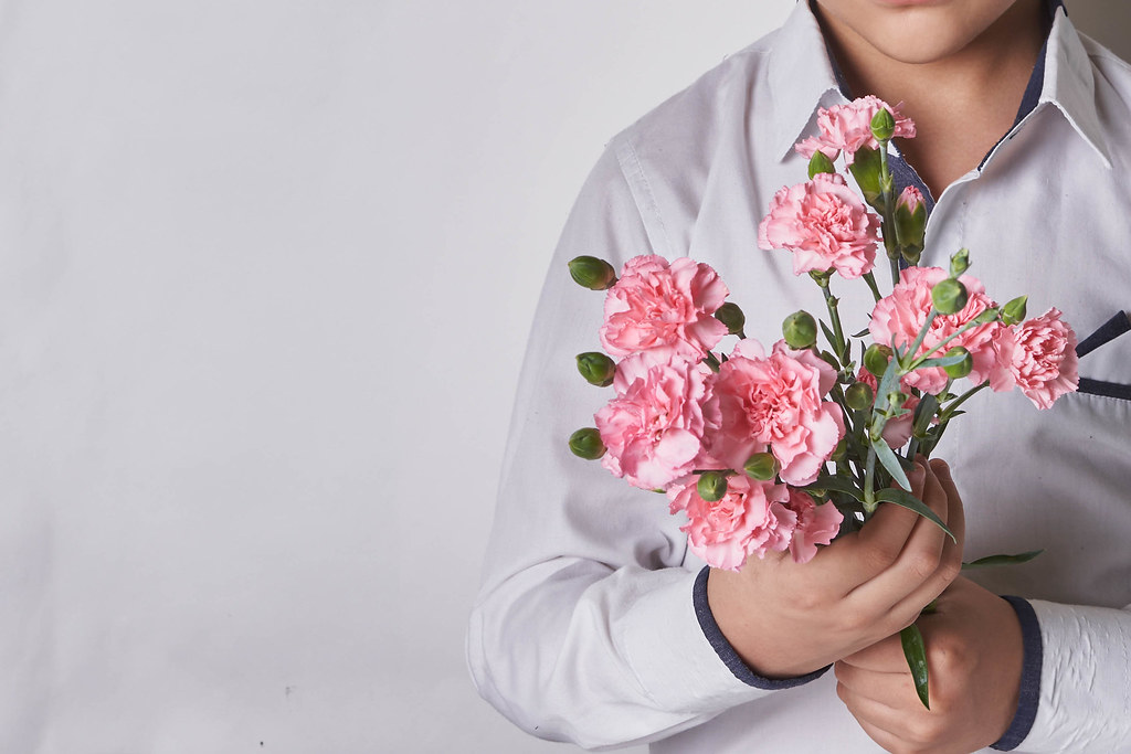 11. A schoolboy holding a bunch of fresh rose flowers.jpg