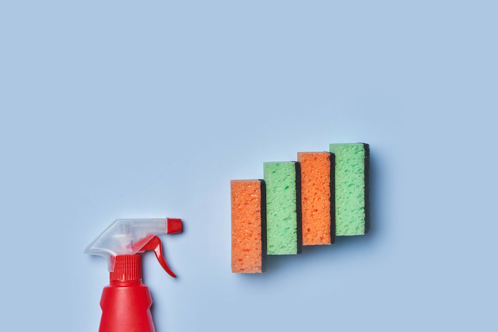 19. Cleaning supplies - bottle and sponges on bright pastel background with copy space.jpg