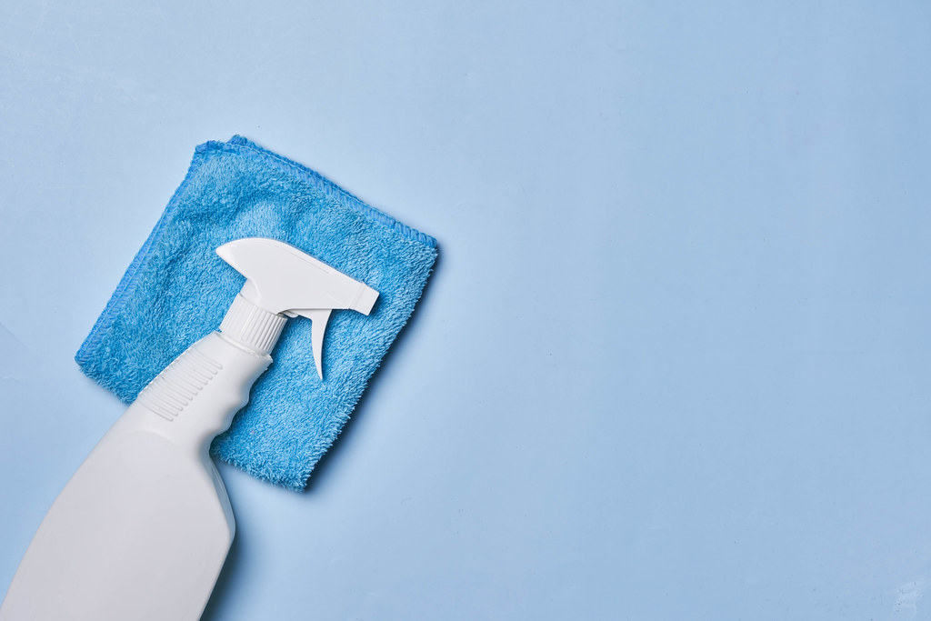 20. Cleaning spray bottle on blue napkin over bright blue background. Flat lay, top view. Cleaning concept.jpg