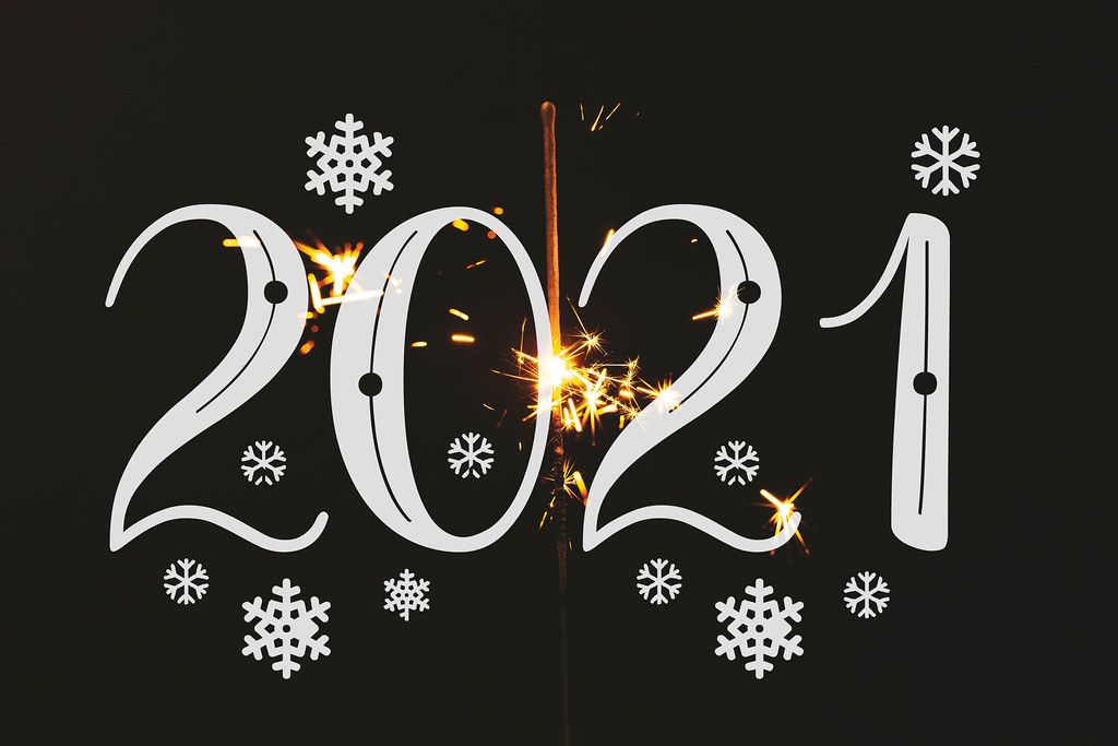 2021 on a black background with snowflakes and a burning sparkler