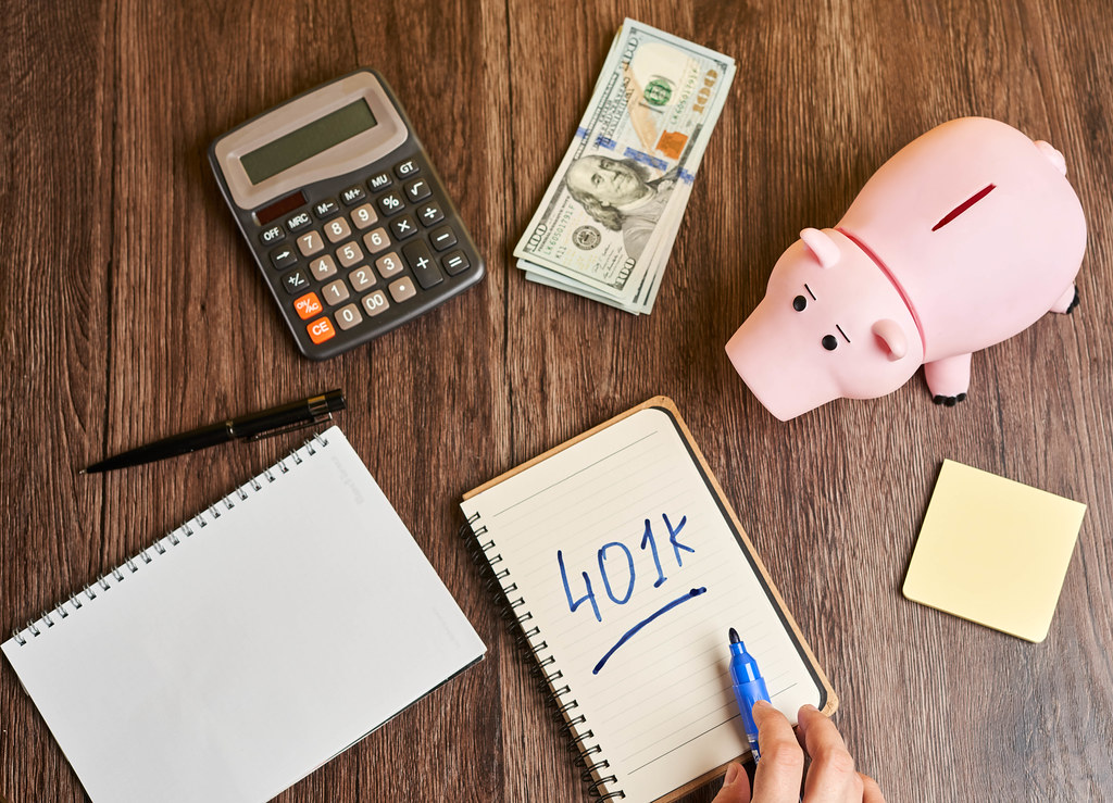 401k planning - piggy bank, calculator and notepad on the table