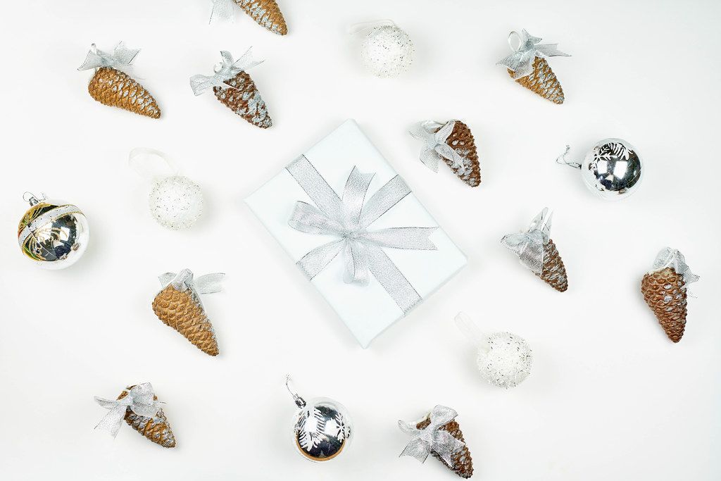 A beautiful arrangement of decorative pine cones and white X-mas giftbox