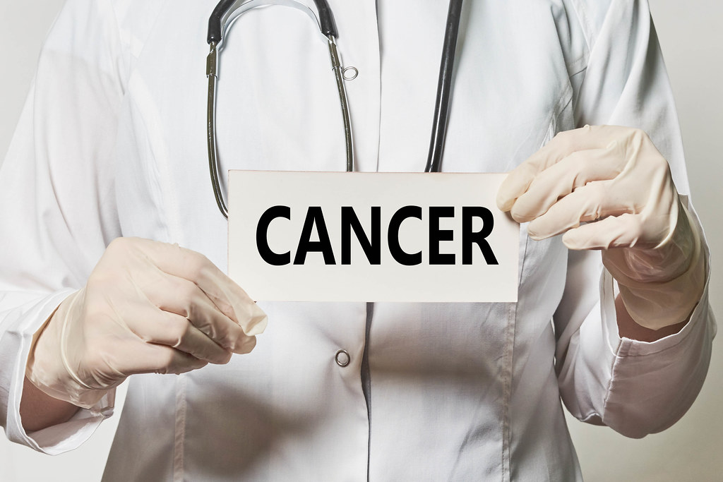 A card with Cancer word in hands of medical worker