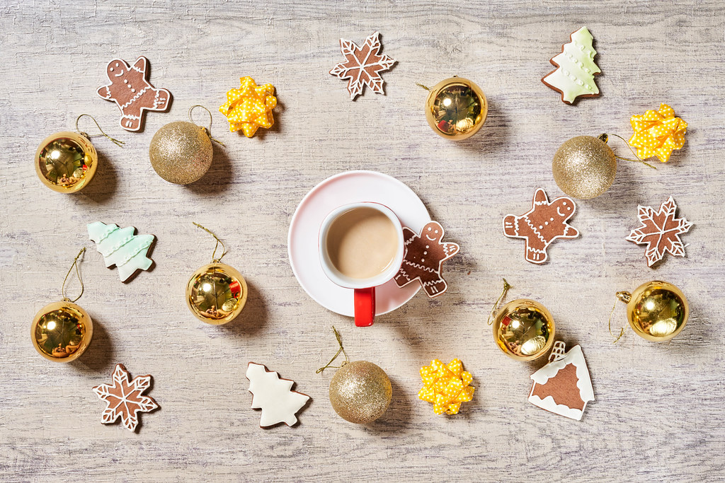 A cup of coffee and Christmas decors with cookies on wood