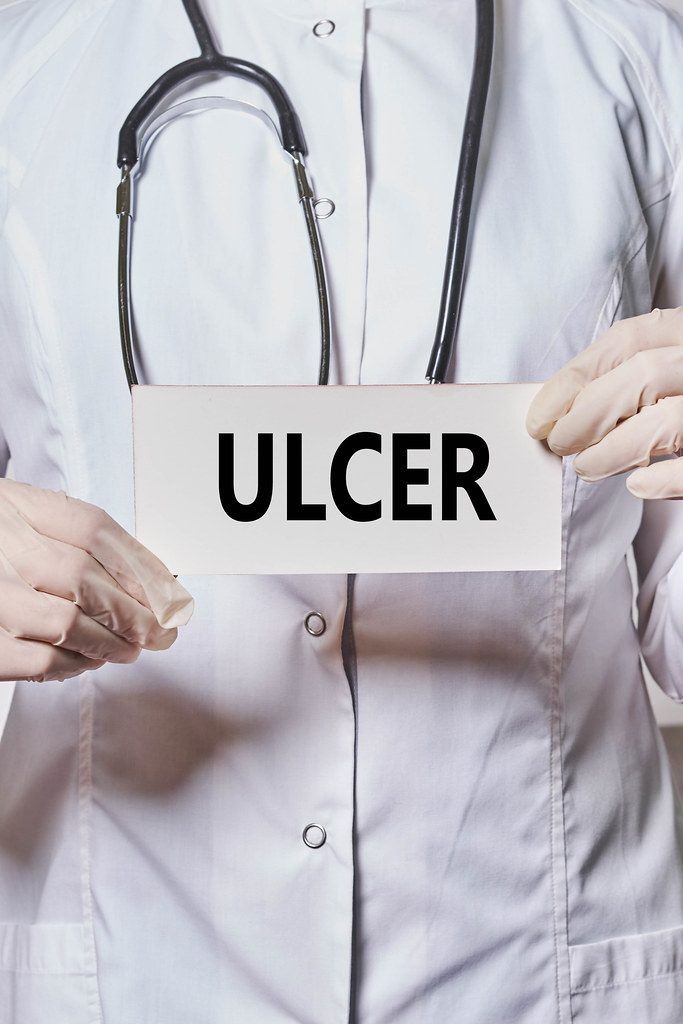 A doctor holds a card with ULCER word