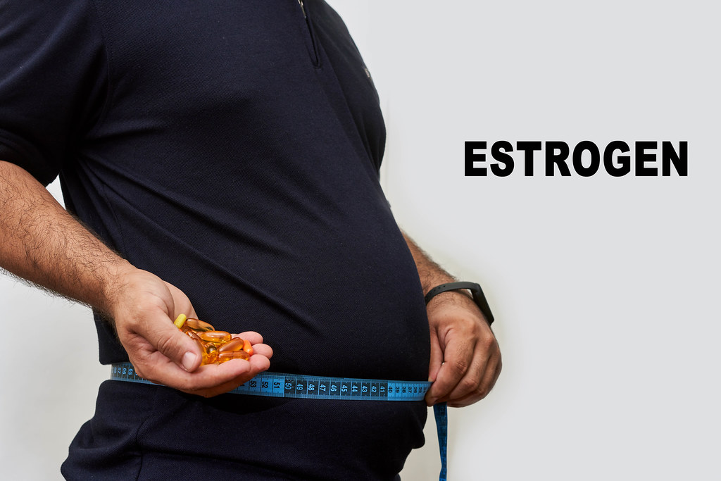 A fat man with fat belly holds pills for estrogen hormone balancing