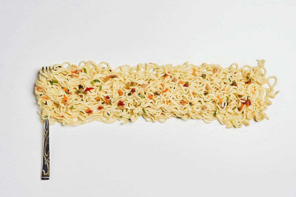 A fork with freshly cooked instant noodles and spices