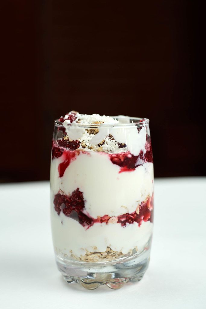 A glass of sweet homemade ice-cream with raspberries and walnuts