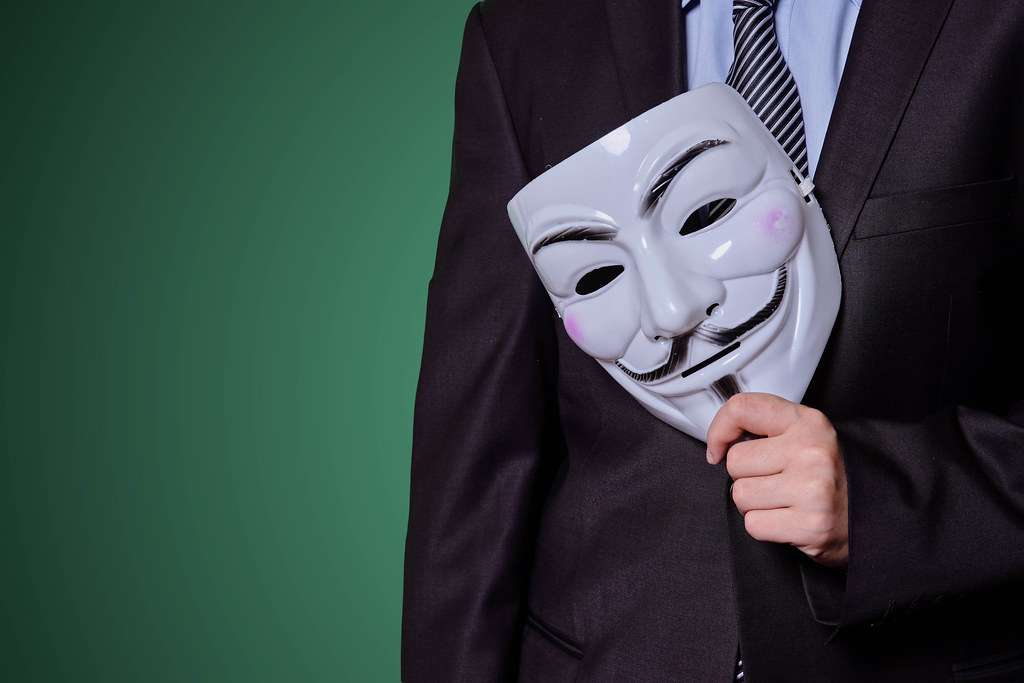 A mysterious man in black suit with an anonymous mask - insider, informant concept