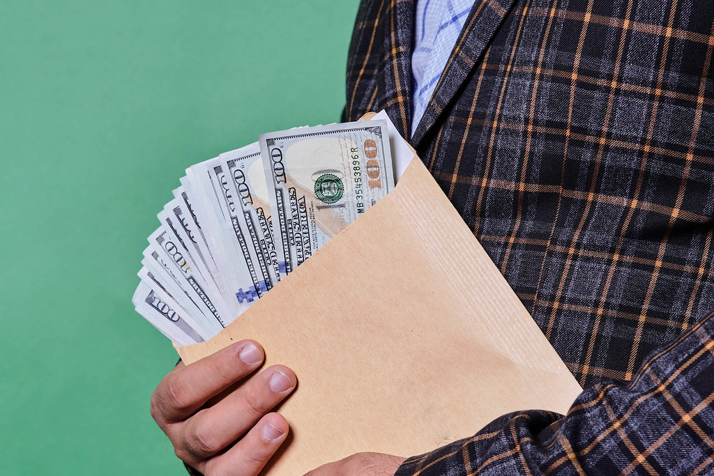 A person holding an envelope with cash. Bribe, corruption