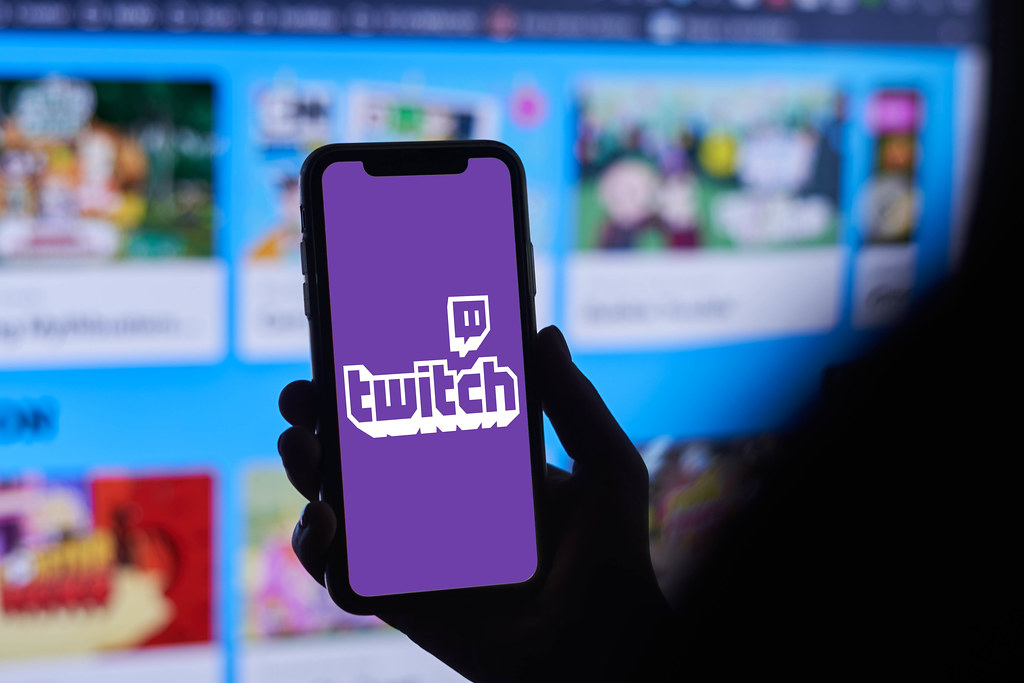 A person holding iPhone app Twitch providing streaming game and video live streaming