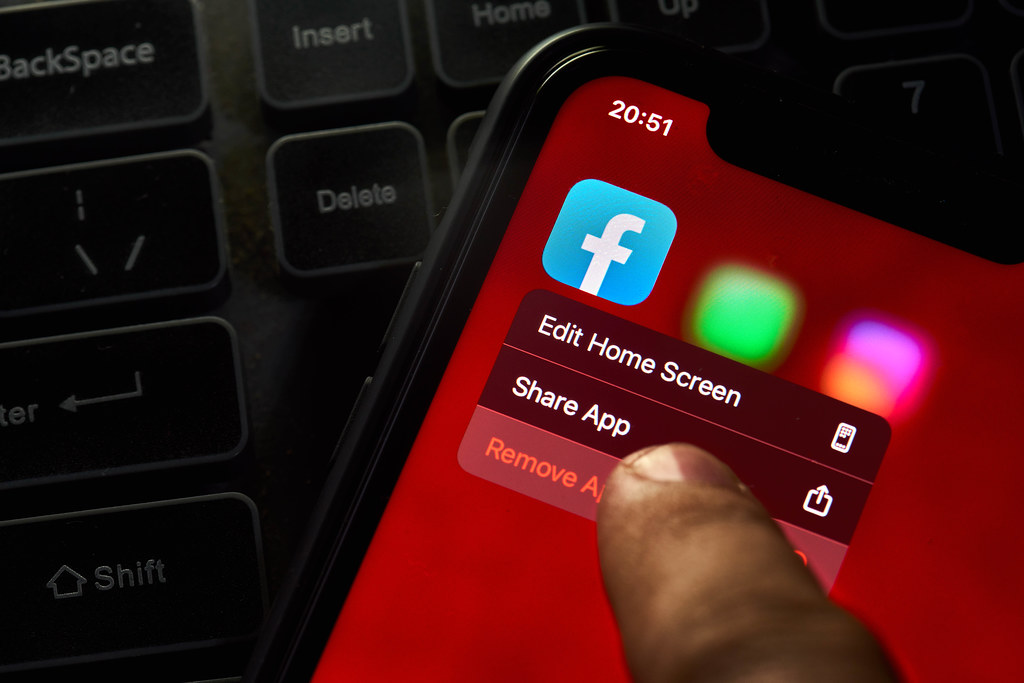 A person removing Facebook mobile application