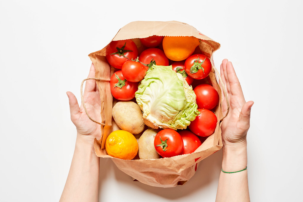 A person with healthy food in a paper bag - shopping food concept