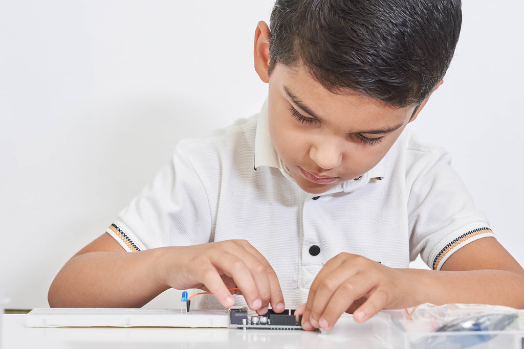 A schoolboy busy with by robotics electronics in laboratory in school